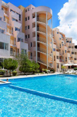 Bulgaristan 'ın Sunny Beach kenti - 05.05.2020: Bulgaristan' ın Karadeniz kıyısındaki en büyük turizm beldesinde yaz mevsimi boyunca sahil kenarındaki şık, rahat ve rahat otel Whit havuzu