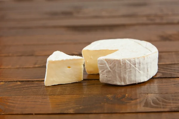 Свежий сыр бри с белой плесенью на белом фоне — стоковое фото
