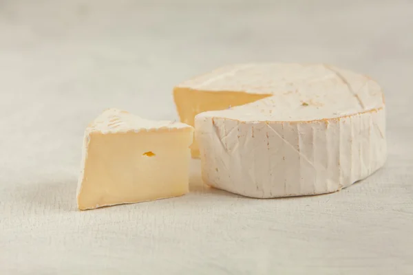 Fresh brie cheese with white mold on a white background — Stock Photo, Image