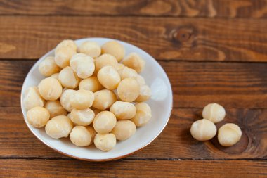 Ahşap zemin üzerinde lezzetli Macadamia fındıkları.