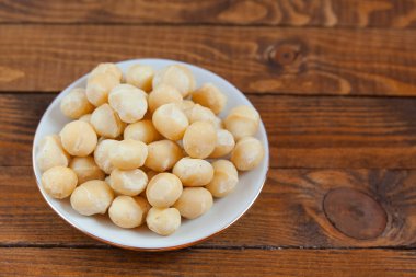 Ahşap zemin üzerinde lezzetli Macadamia fındıkları.