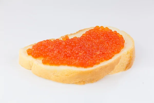 Läcker aptitretande smörgås med röd kaviar på vit — Stockfoto