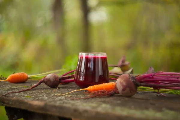 Suco de beterraba-cenoura em vidro na mesa — Fotografia de Stock