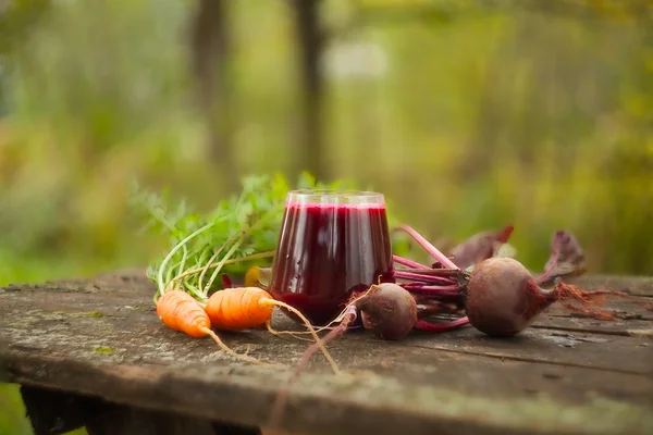 Suco de beterraba-cenoura em vidro na mesa — Fotografia de Stock