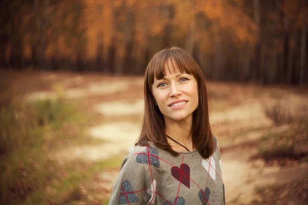 Mooie vrouw permanent en lachend in de natuurlijke backg van de abeautiful — Stockfoto