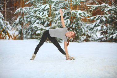 güzel kadın açık havada karda yoga yaparken 