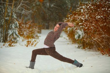güzel kadın açık havada karda yoga yaparken 
