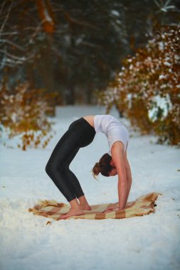 güzel kadın açık havada karda yoga yaparken 