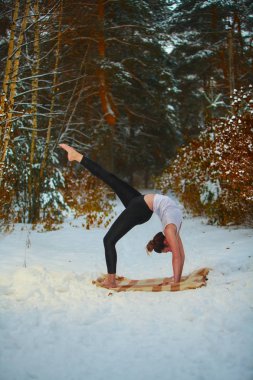 güzel kadın açık havada karda yoga yaparken 