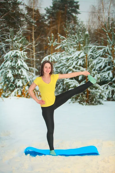 Bella donna che fa yoga all'aperto nella neve — Foto Stock