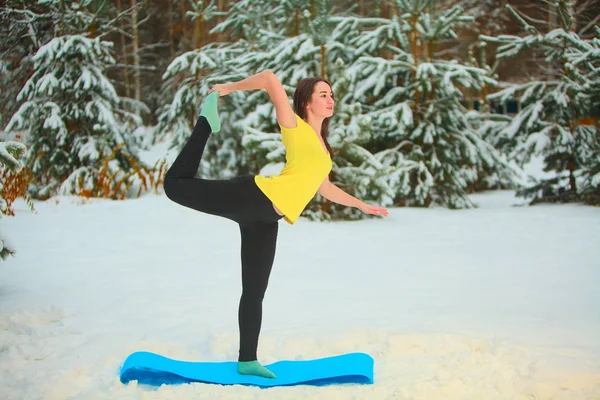 美丽的女人在户外在雪地里做瑜伽 — 图库照片