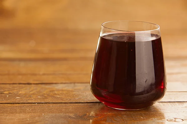 Delicious juice from ripe pomegranate in beautiful glass on wood — Stock Photo, Image