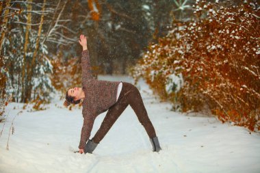 güzel kadın açık havada karda yoga yaparken 