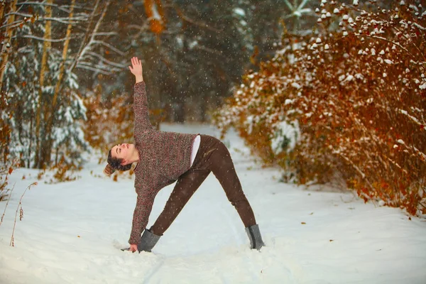Güzel kadın açık havada karda yoga yaparken — Stok fotoğraf