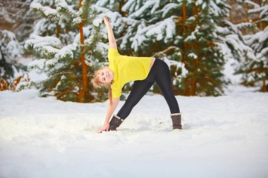 güzel kadın açık havada karda yoga yaparken 