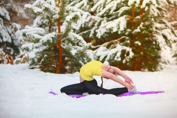 Krásná žena, která dělá jógu venku ve sněhu — Stock fotografie