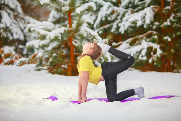 Krásná žena, která dělá jógu venku ve sněhu — Stock fotografie