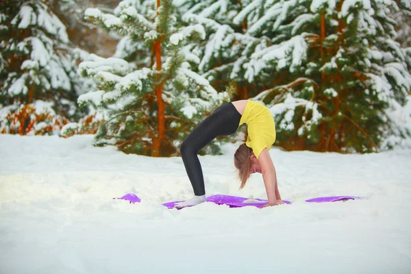 Bella donna che fa yoga all'aperto nella neve — Foto Stock