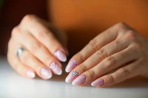Vrouwelijke roze Franse manicure op mooie achtergrond — Stockfoto