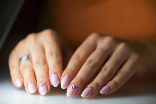 Vrouwelijke roze Franse manicure op mooie achtergrond — Stockfoto