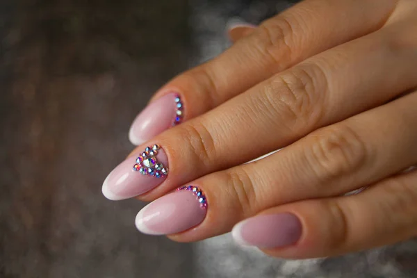 Vrouwelijke roze Franse manicure op mooie achtergrond — Stockfoto