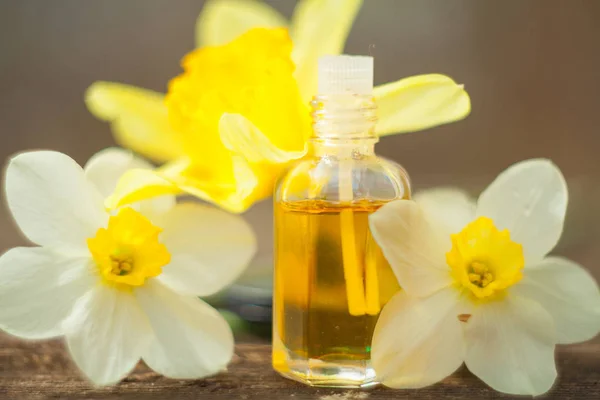 Esencia de flores en la mesa en un hermoso frasco de vidrio — Foto de Stock