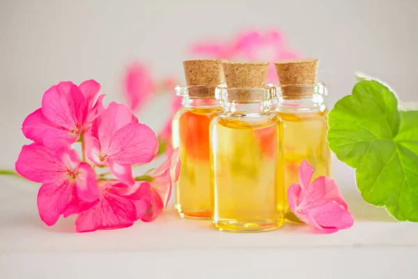 Esencia de flores en la mesa en un hermoso frasco de vidrio — Foto de Stock