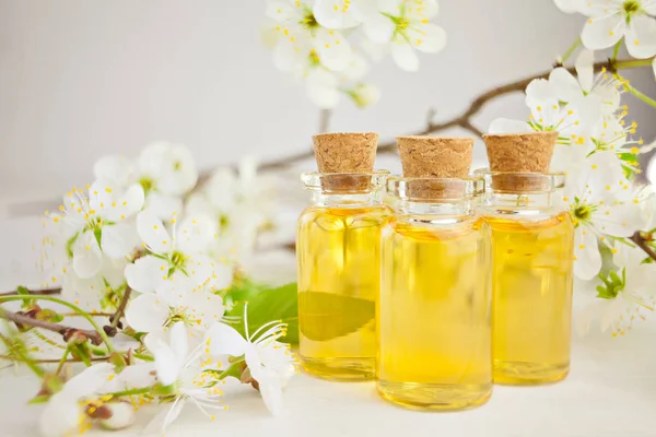 Esencia de flores en la mesa en un hermoso frasco de vidrio — Foto de Stock