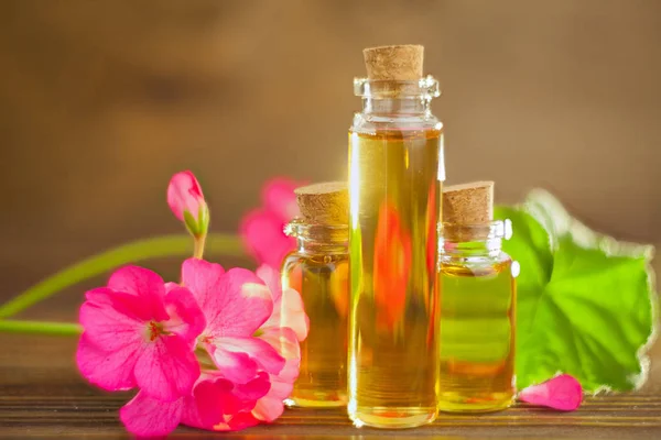 Esencia de flores en la mesa en un hermoso frasco de vidrio — Foto de Stock