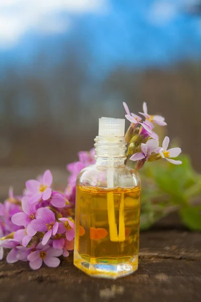 El óleo etérico de la flor arábiga sobre la mesa en la botella hermosa — Foto de Stock