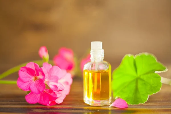 Esencia de flores en la mesa en un hermoso frasco de vidrio — Foto de Stock