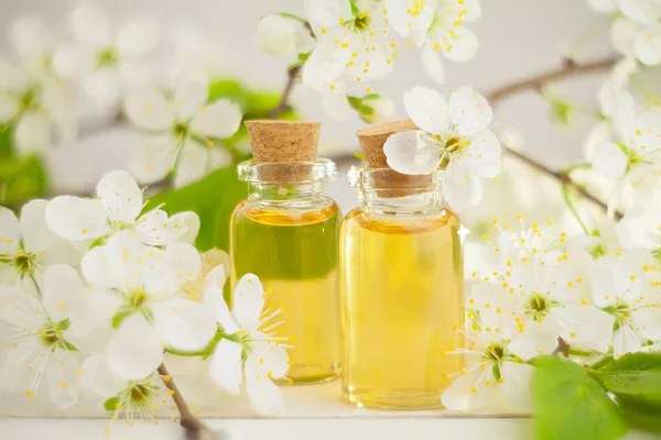 Esencia de flores en la mesa en un hermoso frasco de vidrio — Foto de Stock