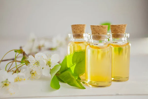 Esencia de flores en la mesa en un hermoso frasco de vidrio — Foto de Stock