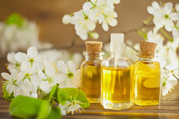 Esencia de flores en la mesa en un hermoso frasco de vidrio — Foto de Stock