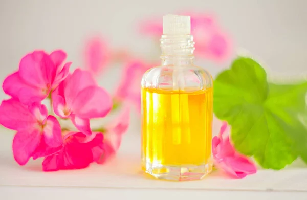 Esencia de flores en la mesa en un hermoso frasco de vidrio — Foto de Stock