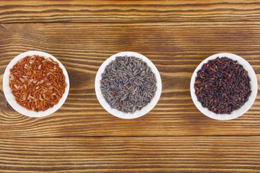 Ahşap arka plan üzerinde kapta çiğ mavi pirinç 