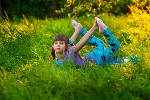 做瑜伽户外在绿色草地上的漂亮女孩 — 图库照片