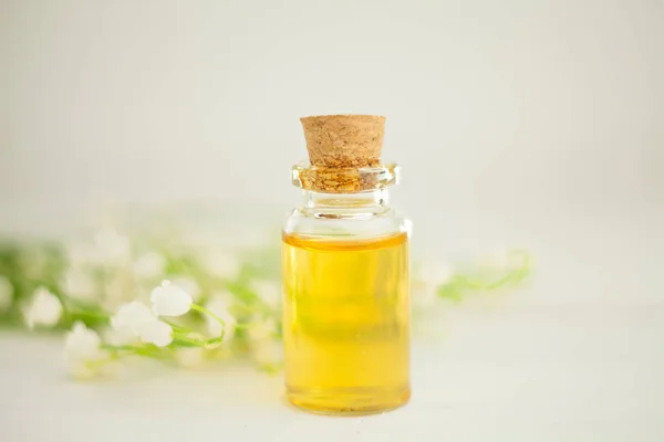 Esencia de flores en la mesa en un hermoso frasco de vidrio — Foto de Stock