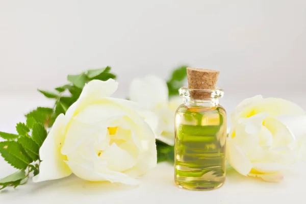 Esencia de flores en la mesa en un hermoso frasco de vidrio — Foto de Stock