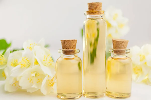 Esencia de flores en la mesa en un hermoso frasco de vidrio — Foto de Stock