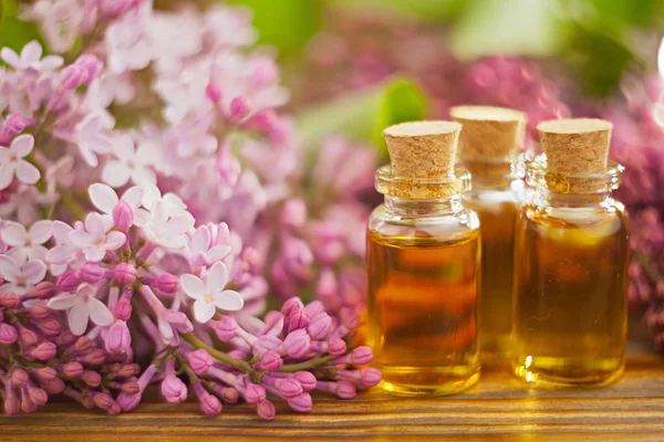 Esencia de flores en la mesa en un hermoso frasco de vidrio — Foto de Stock