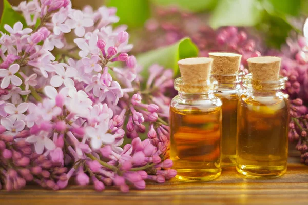 Esencia de flores en la mesa en un hermoso frasco de vidrio — Foto de Stock