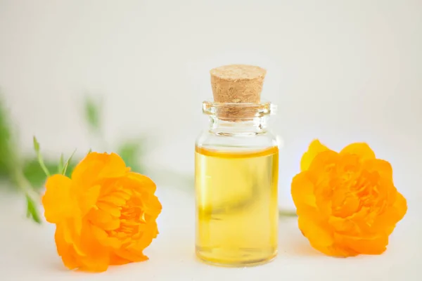 Esencia de flores en la mesa en un hermoso frasco de vidrio — Foto de Stock