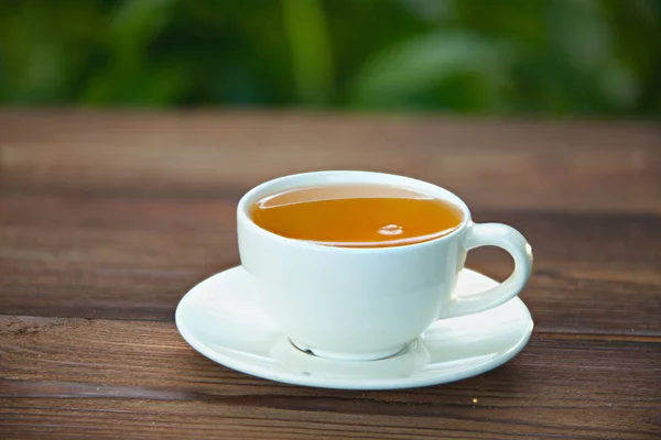 Porzellantasse mit grünem Tee auf dem Tisch — Stockfoto