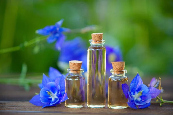 Esencia de flores en la mesa en un hermoso frasco de vidrio — Foto de Stock