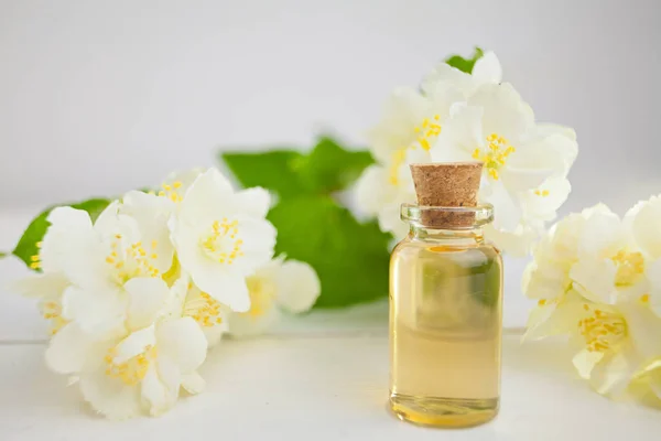 Esencia de flores en la mesa en un hermoso frasco de vidrio — Foto de Stock