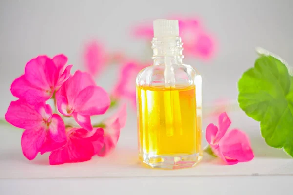 Esencia de flores en la mesa en un hermoso frasco de vidrio — Foto de Stock