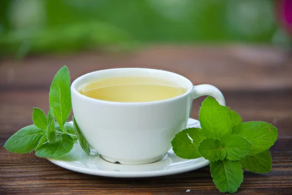 Tazza di porcellana con tè verde sul tavolo — Foto Stock