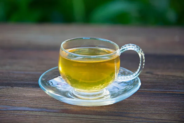 Kristallbecher mit grünem Tee auf dem Tisch — Stockfoto