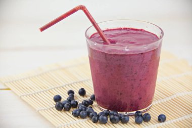 Yaban mersini milkshake beyaz masada güzel cam